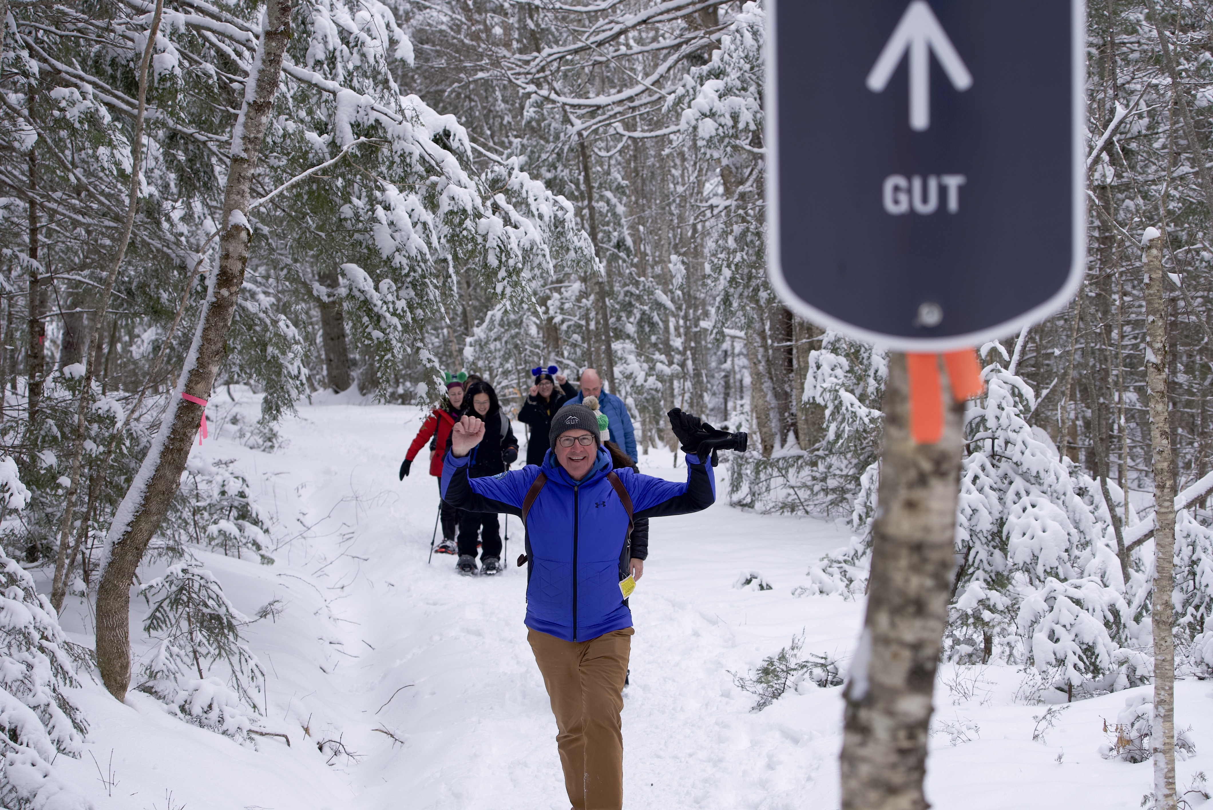 Picture shows people hiking up a ski hill