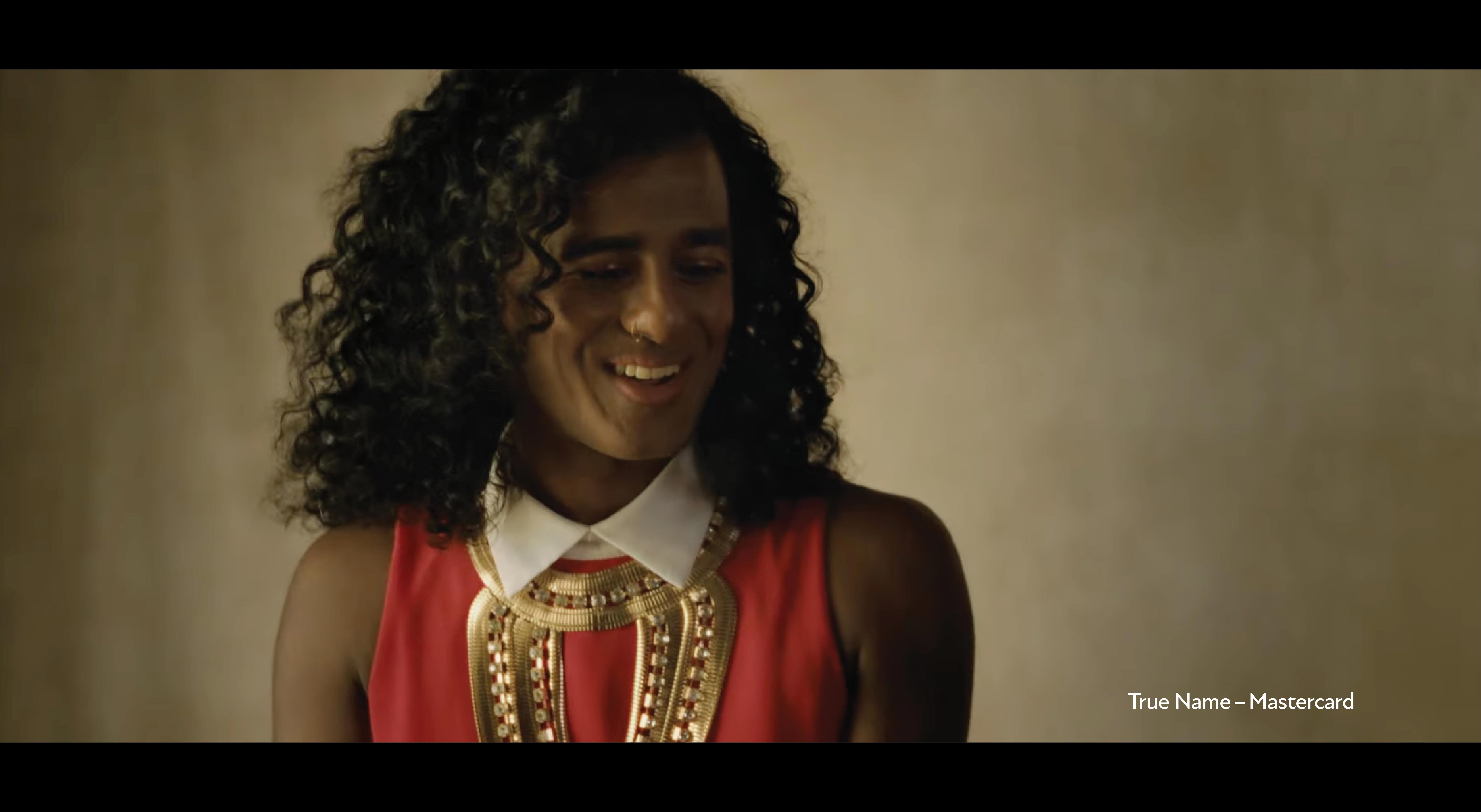Screen grab from MasterCard advertisement showing a person with curly hair smiling