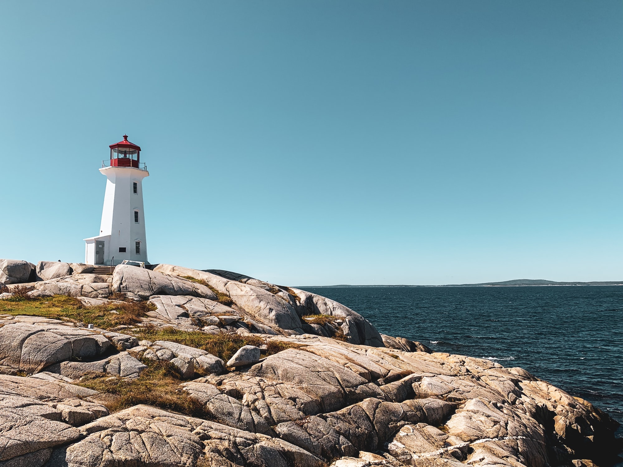 Peggy's Cove iconic lighthouse standing tall on rugged Nova Scotian coastline showcasing a beautifully serene landscape